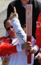 Andrew Michael holds Olympic torch and Team Tibet badge
